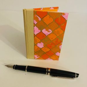 orange and pink small notebook